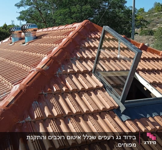גג רעפים עם חלון פתוח ושני ארובות מתכת